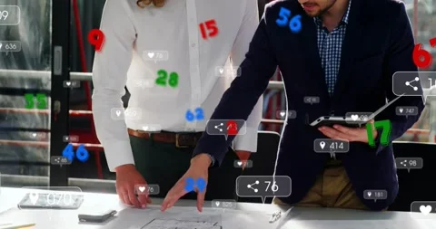 Right man tapping tablet, left man leaning over plans with floating metrics Stock Footage 321453501