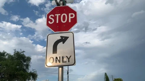 Right only turn and stop road sign on the background of cloudy sky 스톡 동영상 124190614