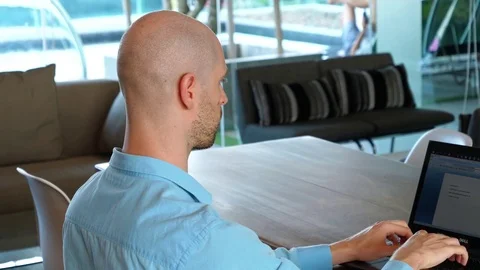 Right over the shoulder white man on laptop Stock Footage 84586601