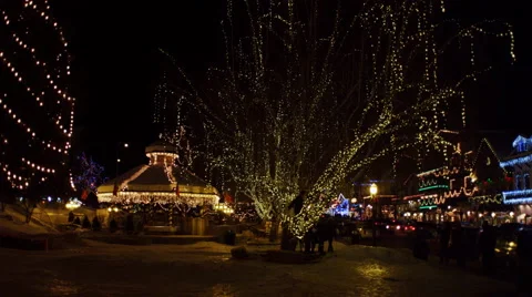 Right pan over a park beside a village street decorated with Christmas lights Stock Footage 59120057