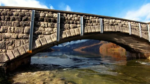 Right pan stone ancient arch bridge rapid river leaving Bohinj lake Stock Footage 120690899