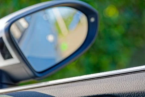 Right side car mirror with open window and bright sun Stock Photos