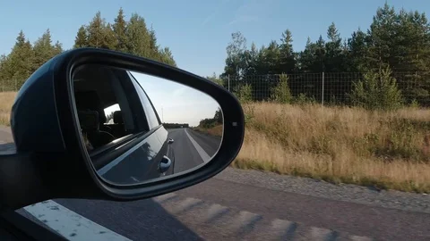 Right side view of a car driving in a country road with mirror showing rear view Stock Footage 114038015