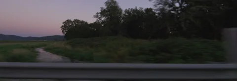 Right Side view of a Driving Plate: Car travels at dusk past farms and vineyards Stock Footage 59330059