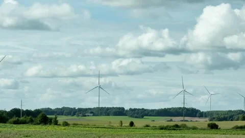 Right side view driving plate of wind turbines on field under dramatic clouds 動画素材 345844116