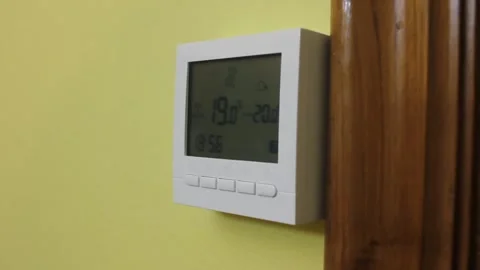 Right side view of a heating thermostat in a yellow wall Stock Footage 322026879