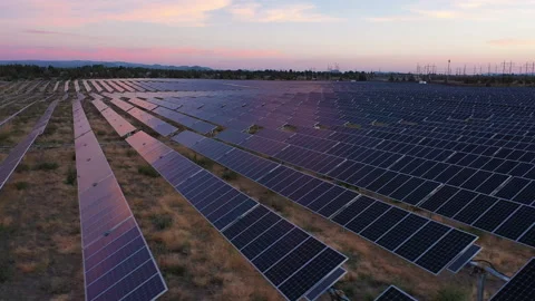 Rightward movement over solar panels with beautiful sunset sky Stock Footage 160889546