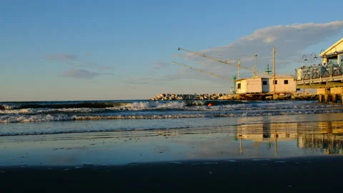 Rimini beach at sunset with real time waves and reflections Stock Footage 135513077
