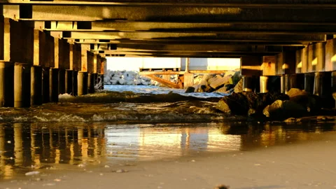 Rimini beach at sunset under the Cervia pier with real time waves and reflection Stock Footage 135513629
