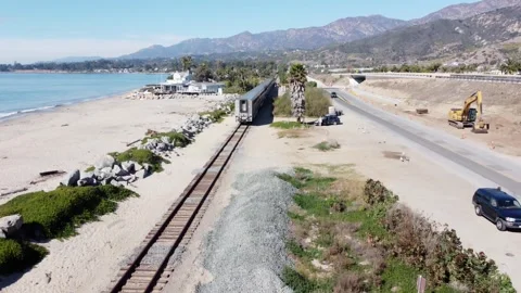 Rincon Beach, CA, USA-2025, February 1: Aerial view of train riding past ocean Stock Footage 302121330