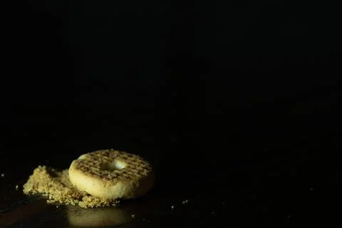 Ring biscuit with crumbs on dark table Stock Photos