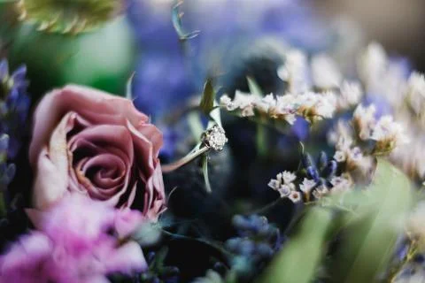 Ring of the bride with a precious stone on a background of blue flowers and a Stock Photos