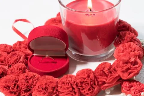 The ring in a case in the form of a heart stands on a white table. Composition Stock Photos