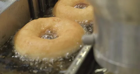 Ring donuts are fried in an automatic deep fryer in hot vegetable oil Stock Footage 270294033