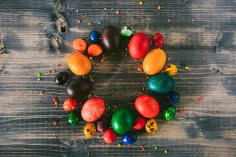 A ring of Easter eggs on a wooden background. A circle of colorful eggs and 스톡 사진