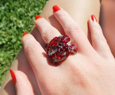 Ring jewellery with red ruby crystals on finger Stock Photos