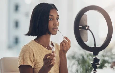 Ring light, lip gloss and woman in home with makeup for beauty tutorial, li.. Foto stock