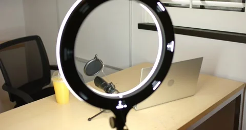 Ring light is starting rotation on tripod, shifting circle, revealing cup, mic, Stock Footage 335069713