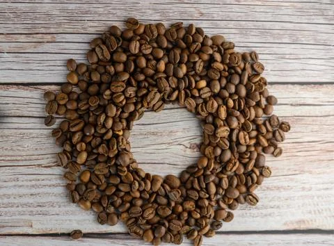 Ring or wreath composition of roasted coffee beans on wooden background Stock Photos