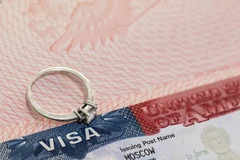 A ring with a precious stone on the background of a US visa as a symbol of Stock Photos