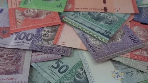 Ringgit Malaysia banknotes of various values are scattered on the table. Stock Footage 95769788