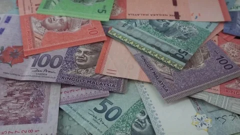 Ringgit Malaysia banknotes of various values are scattered on the table. Stock Footage 95769803