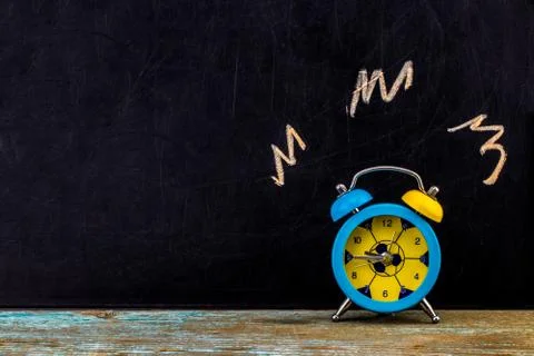 Ringing alarm clock on dark background, suggesting wake-up time or deadline.W Stock Photos