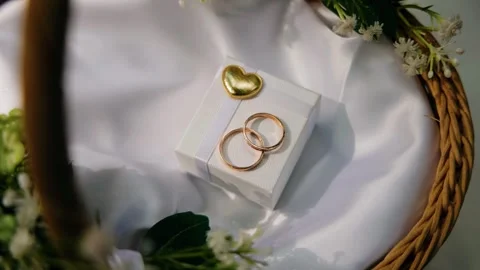 The rings are on a white box in a wicker basket. Shooting from above in motion Stock Footage 323457976