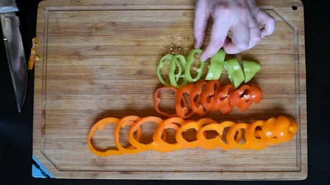 Rings of bell pepper of different colors on a wooden Board background Stock Footage 95564642
