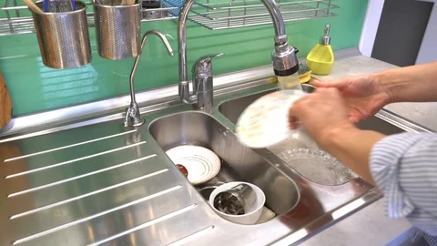Rinse the washed dishes under a diffused stream of water Stock Footage 120615792