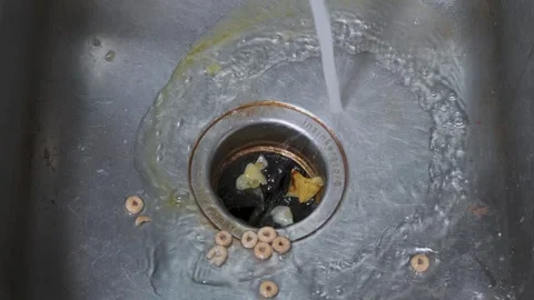 Rinsing food down the drain while cleaning a metal kitchen sink (slow motion) 스톡 동영상 314244393