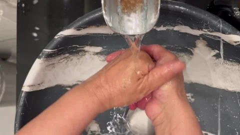 Rinsing Hands Under Running Water in a Modern Sink Video stock 345741146