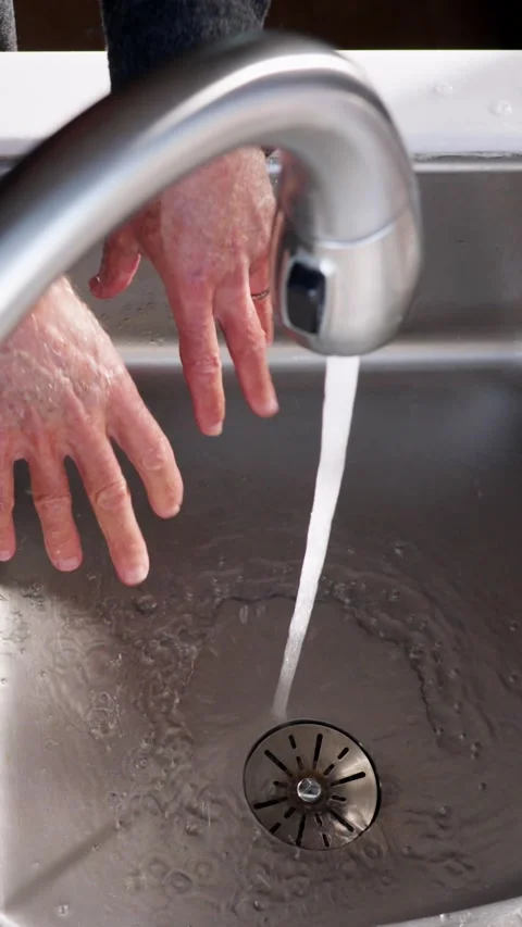 Rinsing man's hands in kitchen sink slow motion vertical video Video stock 289924076