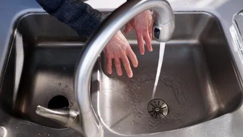 Rinsing man's hands in kitchen sink slow motion Video stock 289926855