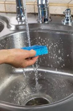 Rinsing soap off of sponge Stock-Fotos
