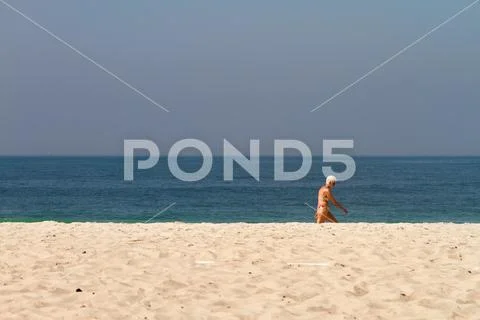 Rio de Janeiro, Brazil - August 21, 2018: An elderly woman with a bikini walk Stock Photos