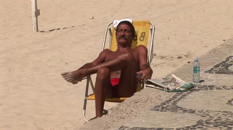 Rio de Janeiro: Man sunbathing on beach near boardwalk Stock Footage 46969840