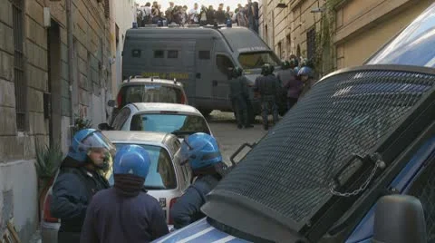 Riot police, demonstrators in background Stock Footage