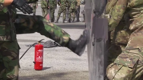 Riot police practice combat exercises against molotov cocktail throwing Stock Footage