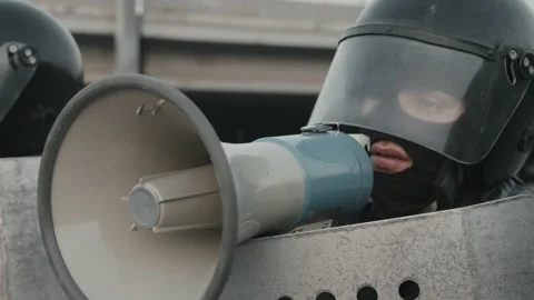 Riot Policeman Talking into Megaphone at Protest Stock Footage 156438310