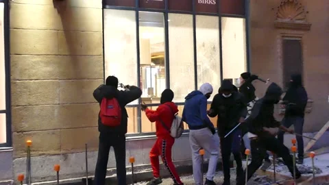 Rioters in red suit violently hit window numerous times Stock Footage 132561127