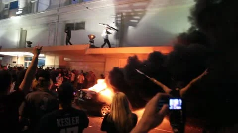 Riots - car burning, man throws wood into fire, chaos, yelling Stock Footage 11234711