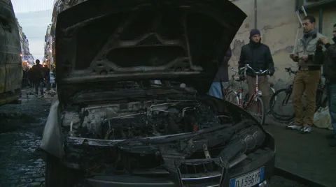 Riots in Rome aftermath - pan from burnt out car to Police van Stock Footage 1066260