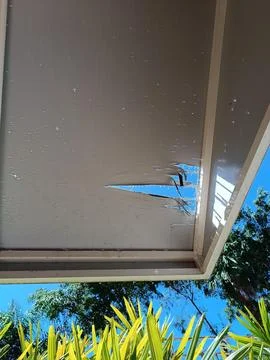 Rip in awning with blue sky in the background Stock Photos