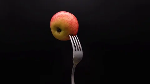 A ripe Apple is rotated on the fork Stock Footage 113470138