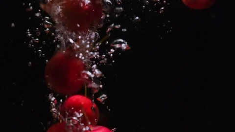 Ripe apples falling in transparent water on black background. Видео 249781918
