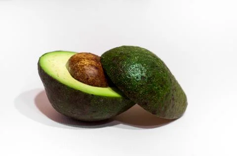 Ripe avocado cut in half on white background Stock Photos
