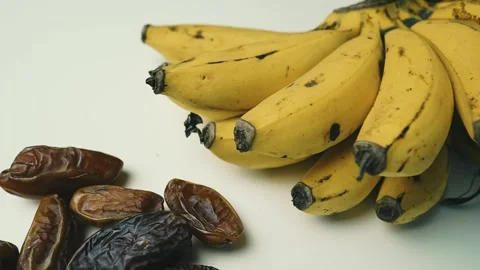 Ripe Bananas and Dried Dates on White Surface, A bunch of ripe bananas next.. Vídeo Stock 304974238