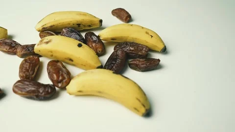 Ripe Bananas and Dried Dates on White Surface, A collection of ripe bananas.. 動画素材 304977441