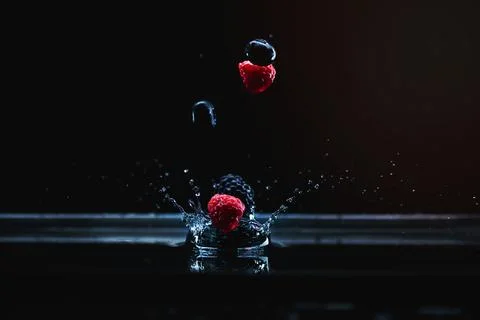 Ripe berries falling in water Stock Photos
